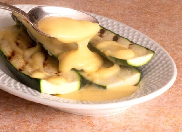 a picture of Greek avgolemono egg and lemon sauce poured over grilled zucchini