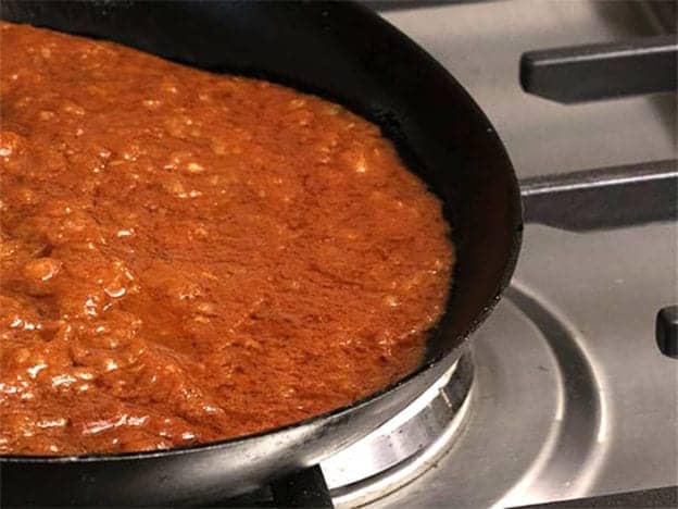 picture of koshari sauce cooking in a skillet